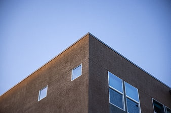 Modern brown building corner against clear blue sky