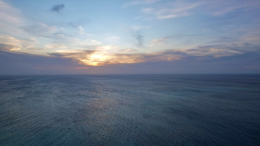 Serene Ocean Sunset with Golden Horizon and Cloudy Sky