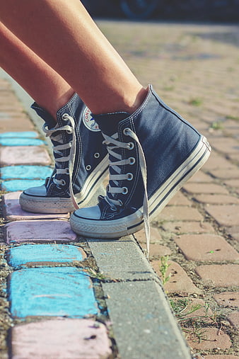 Blue denim high-top sneakers on colorful brick path
