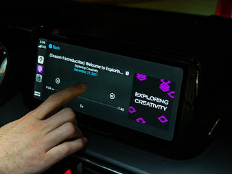 Hand Interacting with Car Infotainment Screen Playing Podcast