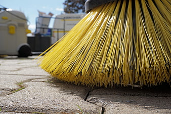 Close-up of yellow street sweeper brush on pavement
