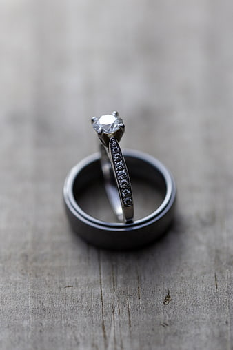 Diamond engagement ring and wedding band on rustic wood