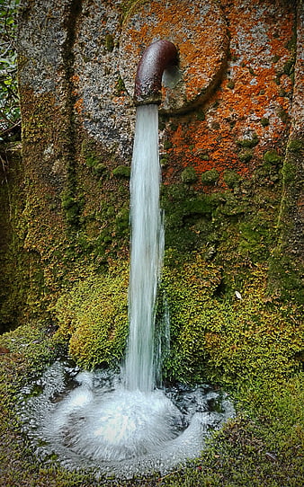 Old Iron Pipe Spouting Water Into Mossy Stone Fountain