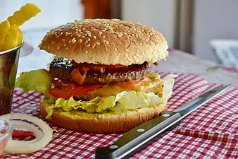 Delicious Cheeseburger With Fries And Onion Rings On Checkered Tablecloth
