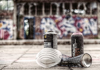 Spray paint cans and mask on abandoned station floor