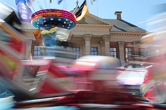 Motion blur carnival ride in front of classical building