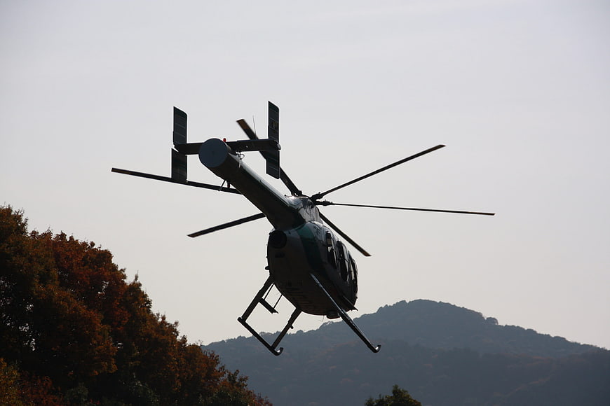 Helicopter flying over autumn mountains and trees