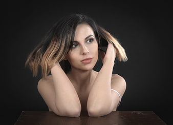 Studio Portrait of Young Woman with Hands in Hair