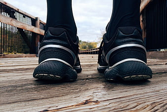 Close-up of black running shoes on wooden deck