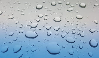 Close-up of water droplets on a blue gradient surface