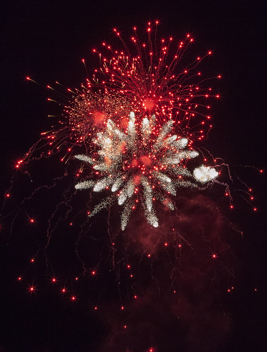 Red and white fireworks exploding in the night sky