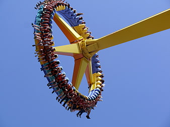 Thrilling amusement park swing ride against blue sky