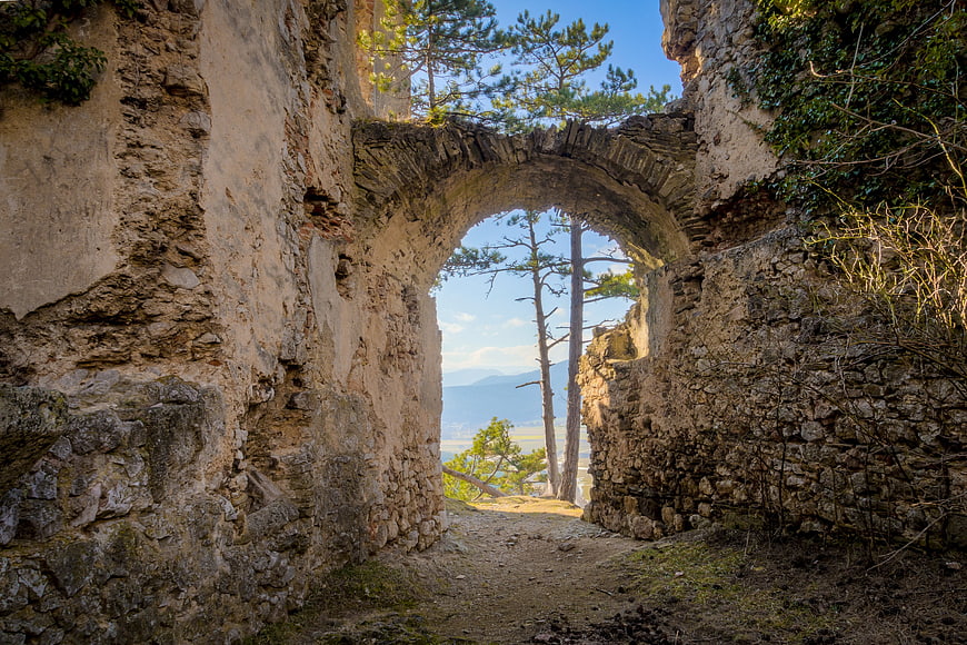 Ancient stone archway ruins overlooking scenic mountain landscape