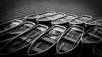Black and white rowboats moored on rippling water