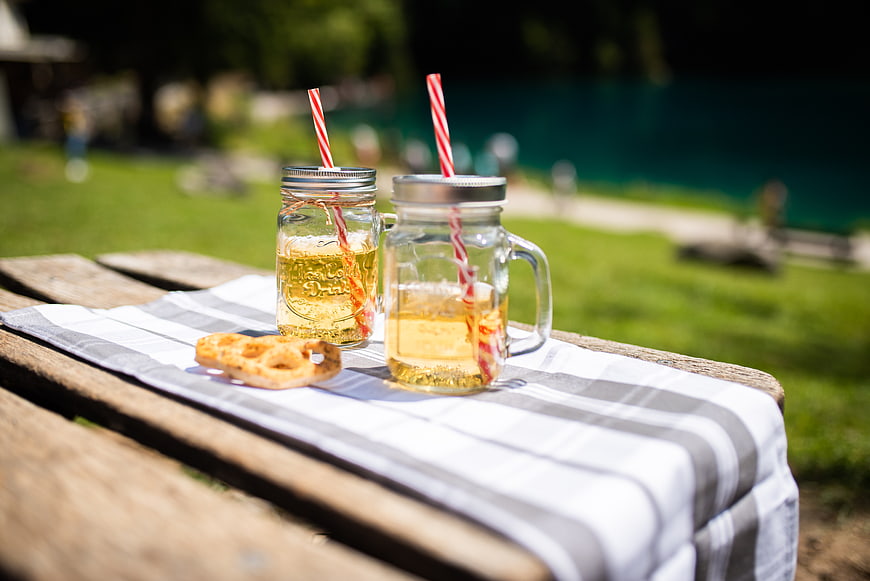 Refreshing lemonade in mason jars with pretzels on a picnic table