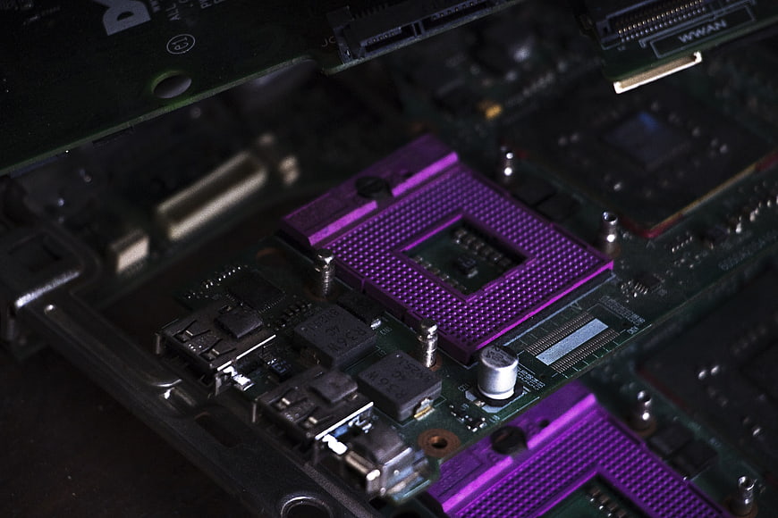 Close-up of purple CPU socket on green motherboard