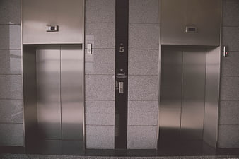 Modern stainless steel elevator doors in a corporate building lobby