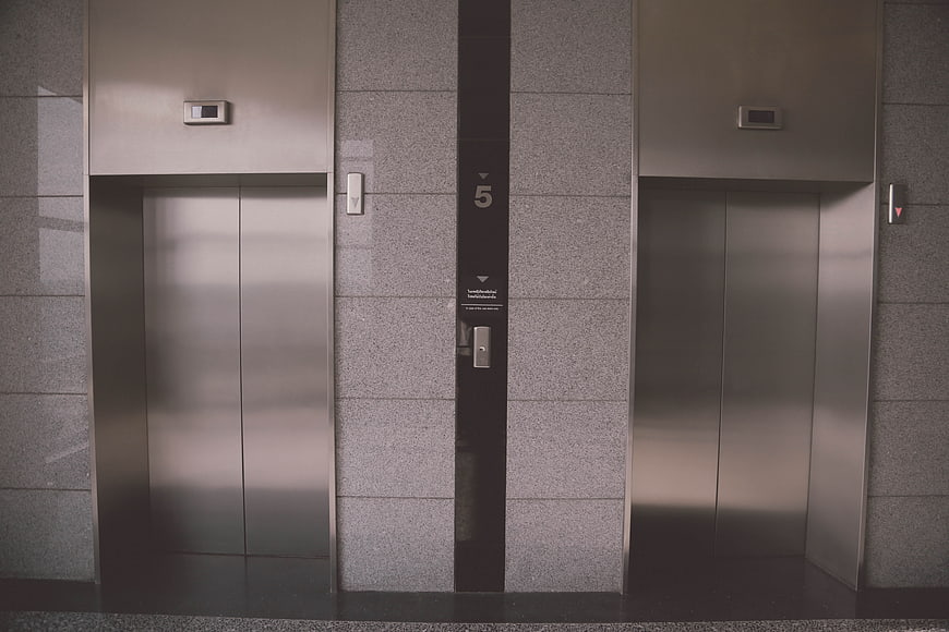 Modern stainless steel elevator doors in a corporate building lobby