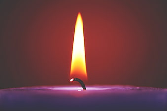 Close-up of a purple candle flame in the dark
