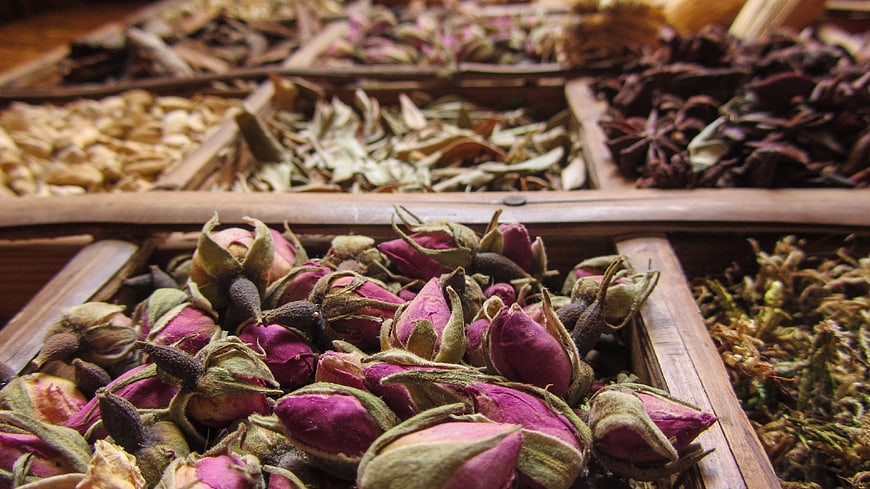 Dried Rose Buds And Spices In Wooden Market Trays
