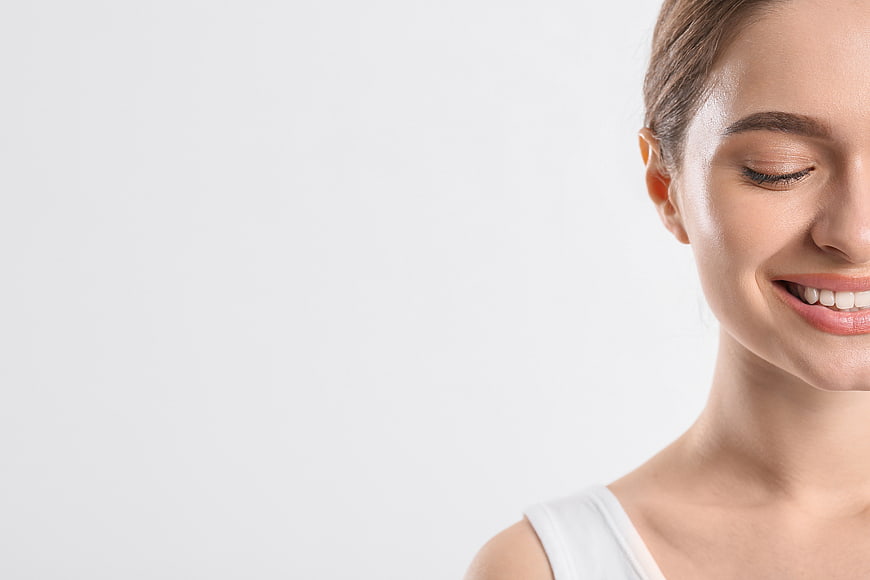 Close-up of smiling woman with healthy skin and white background