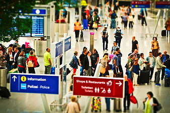 Tilt-shift airport terminal with miniature people and signage