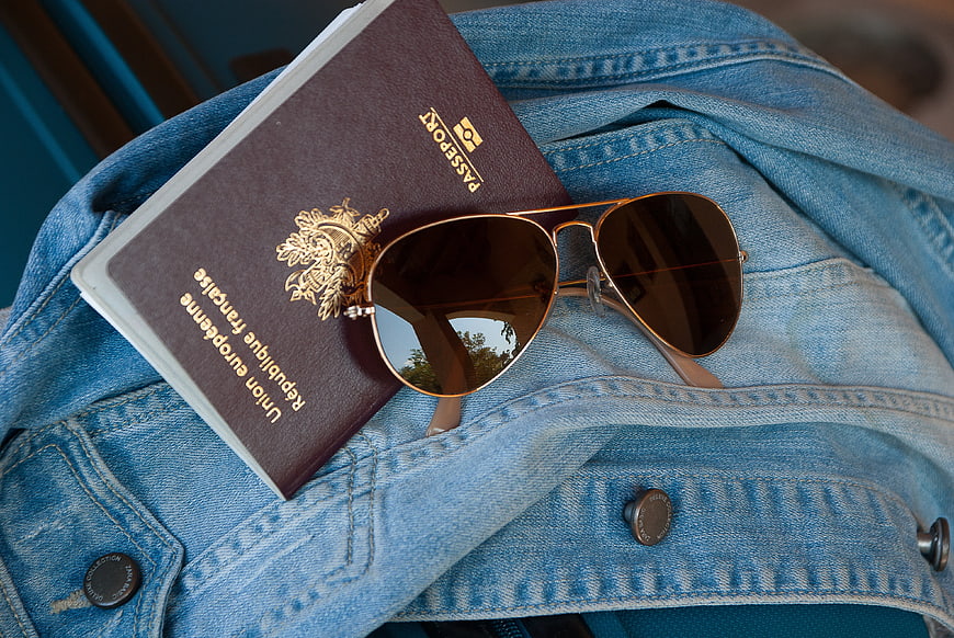 French Passport And Sunglasses On Denim Jacket Travel Concept