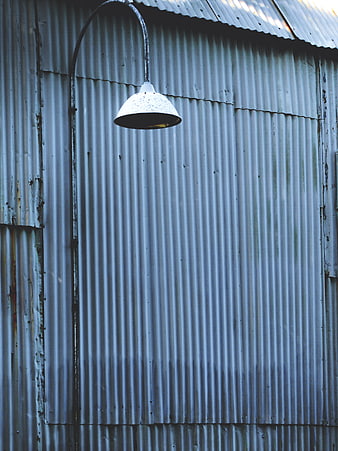 Vintage industrial lamp on corrugated metal wall
