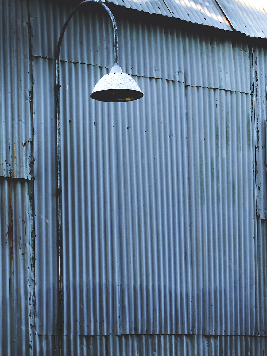 Vintage industrial lamp on corrugated metal wall