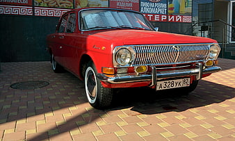 Classic Red Volga Sedan Parked On Paved Street