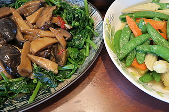 Healthy stir-fried mushrooms and mixed vegetables on wooden table
