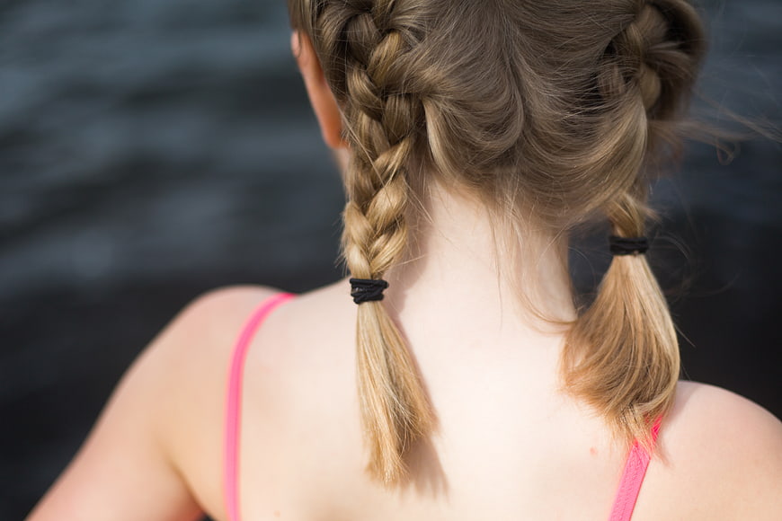 Back view of girl with blonde braided pigtails