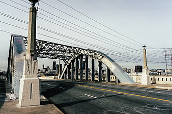 Steel Arch Bridge with City Skyline Background