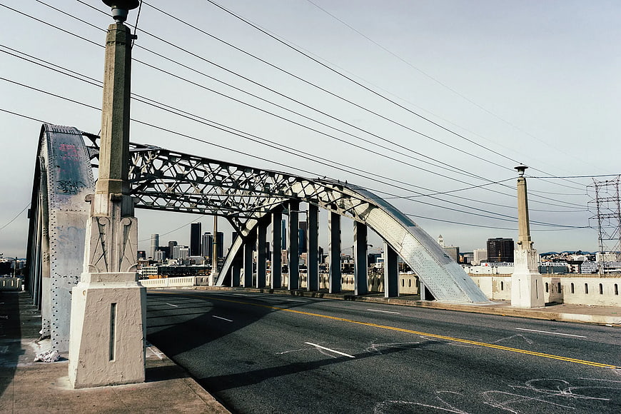 Steel Arch Bridge with City Skyline Background