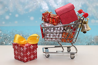 Miniature Shopping Cart Filled With Christmas Gift Boxes And Bells
