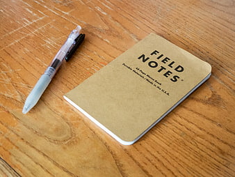Field Notes notebook and pen on wooden desk