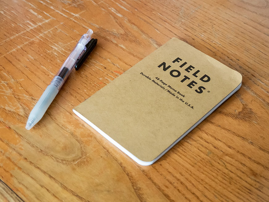 Field Notes notebook and pen on wooden desk