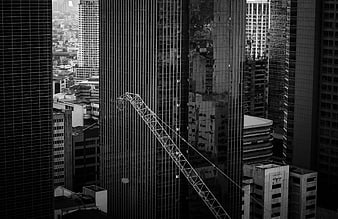 Black and white cityscape with construction crane between skyscrapers