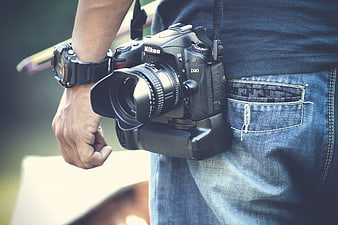 Photographer holding Nikon D90 DSLR camera with battery grip