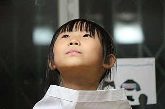 Close-up of young Asian girl looking up with wonder