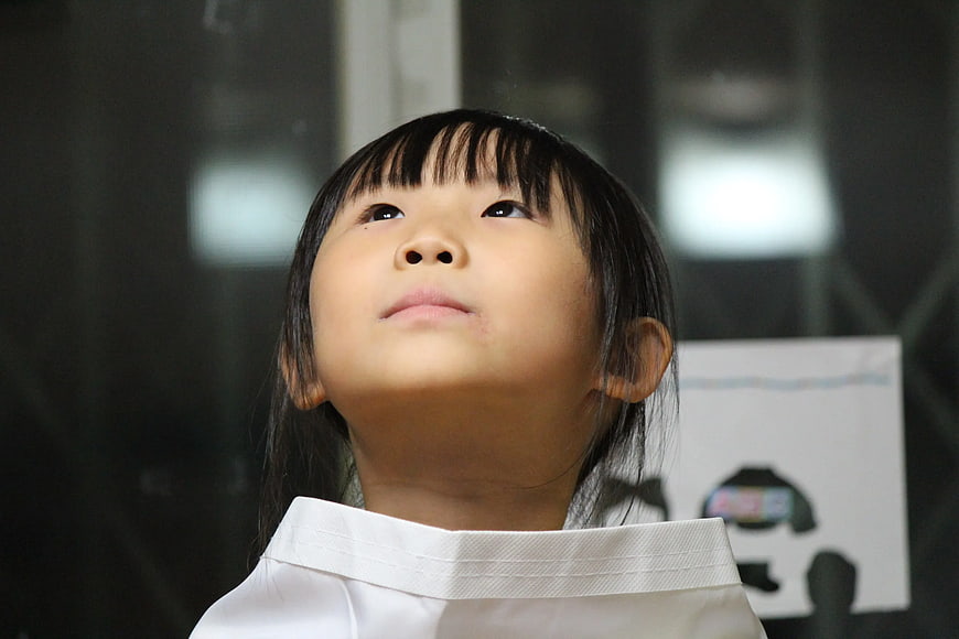Close-up of young Asian girl looking up with wonder