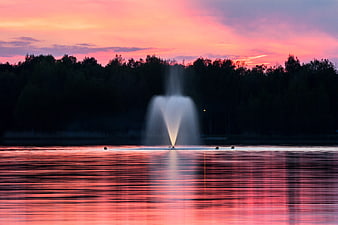 Serene Lake Fountain at Sunset with Pink Sky Reflection
