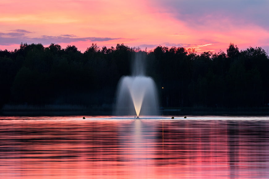 Serene Lake Fountain at Sunset with Pink Sky Reflection