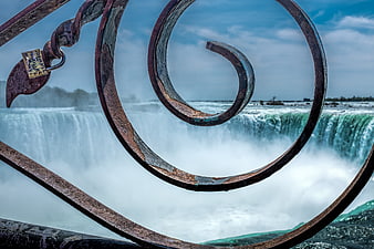 Rusty metal spiral railing with waterfall background
