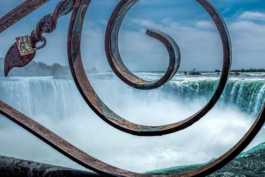 Rusty metal spiral railing with waterfall background