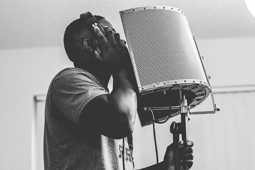 Man Singing into Microphone in Recording Studio