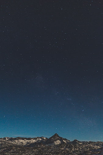 Starry Night Sky Over Snowy Mountain Peaks