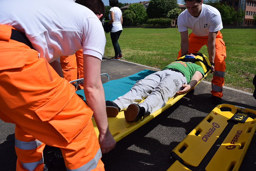 Paramedics loading patient onto stretcher outdoors
