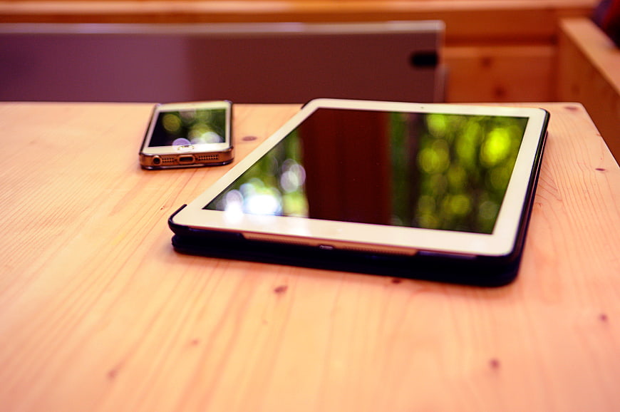 Tablet and Smartphone on Wooden Table with Blurred Background