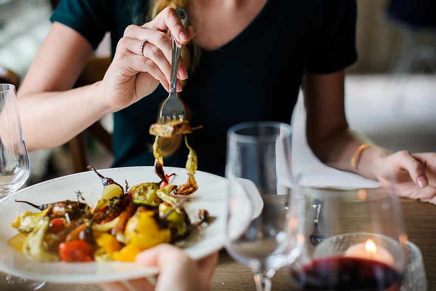 Woman Eating Grilled Vegetables with Red Wine